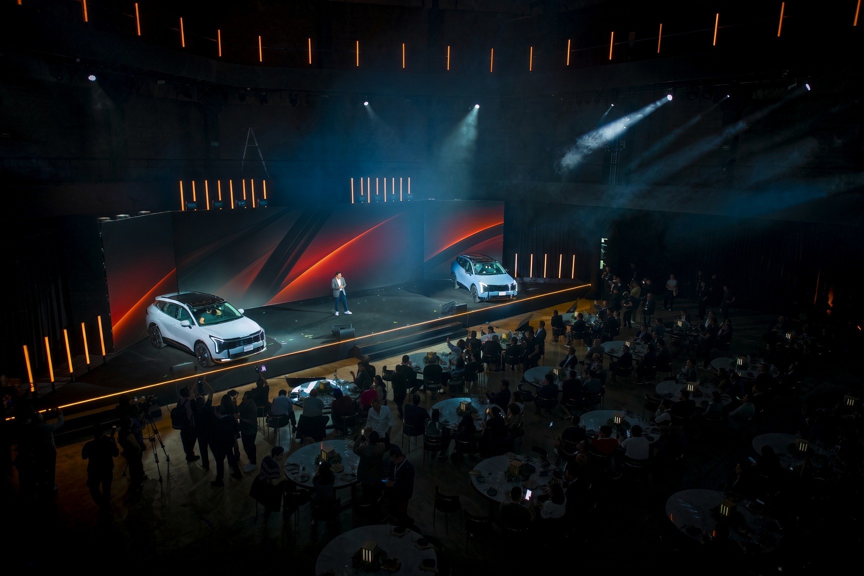 Automotive product launch with stage, vehicles, and seated audience